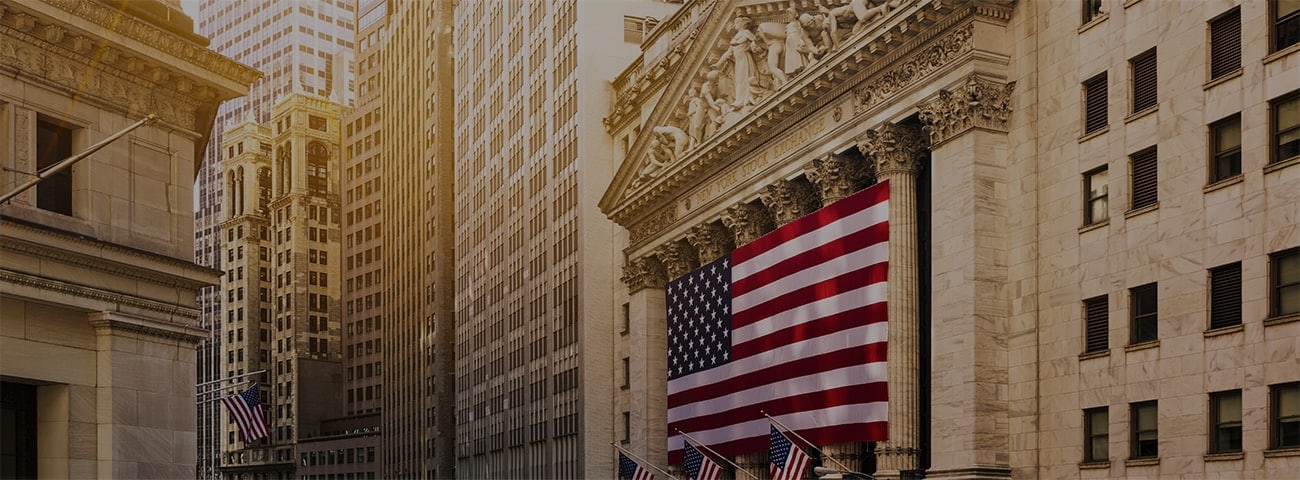 Famous Wall street and the building in New York, New York Stock Exchange with patriot flag.